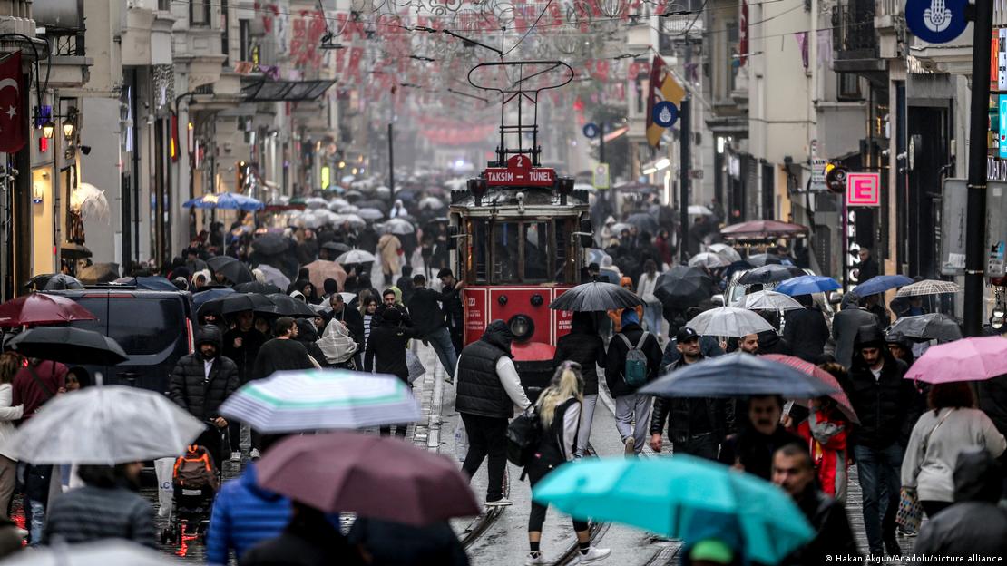 İstanbul - İstiklal Caddesi'nde, ellerinde şemsiyeleri ile insan kalabalığı ve ortada bir tramvay - (07.12.2023)