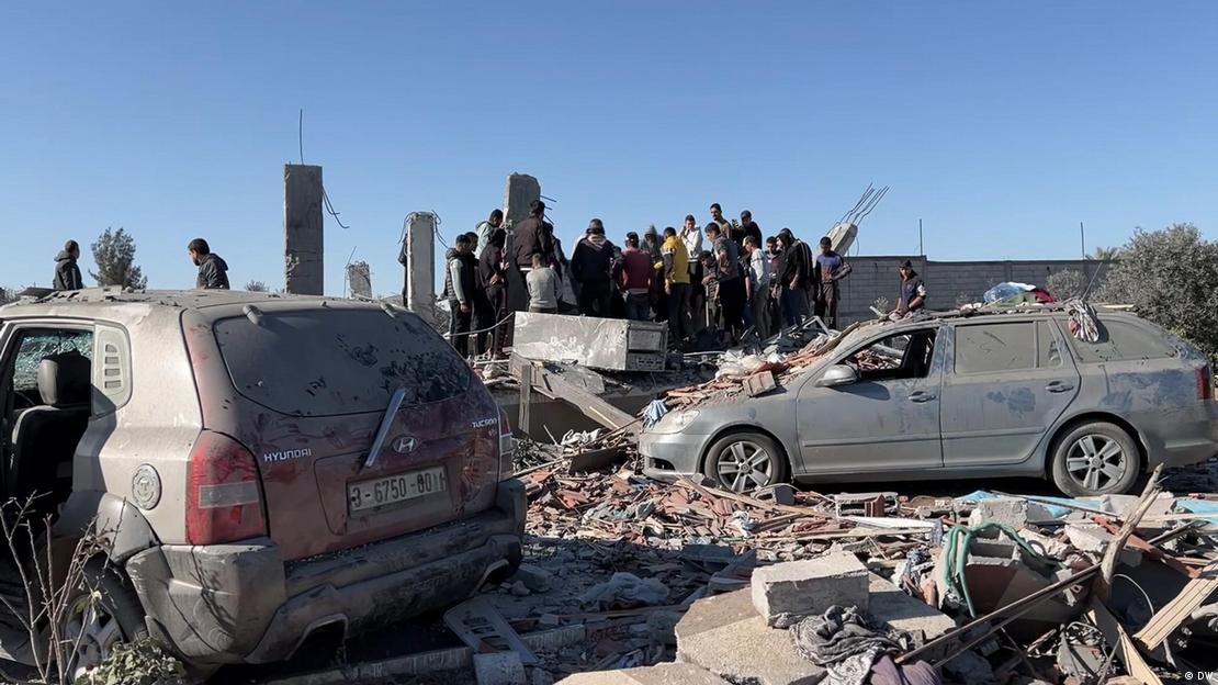 İsrail'in saldırısı sonucu Gazze'de yıkılan bir bina, toplanan kalabalık ve hasar gören araçlar