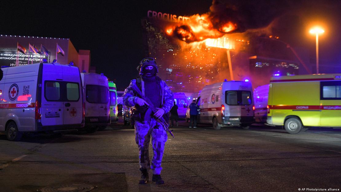 IŞİD'in üstlendiği saldırıda yanan Crocus City Hall adlı konser salonunun önünde çok sayıda ambulans ve eli silahlı, yüzü maskeli bir güvenlik görevlisi - (22.03.2024 / Moskova)